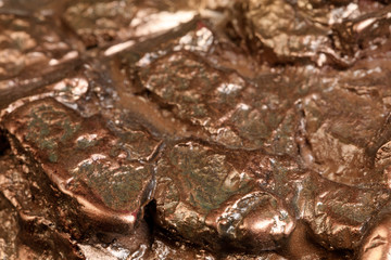 Nugget in bronze. A small lump of bronze in abstract forms, modeled and painted for a decorative object. Macro. Extreme close up.