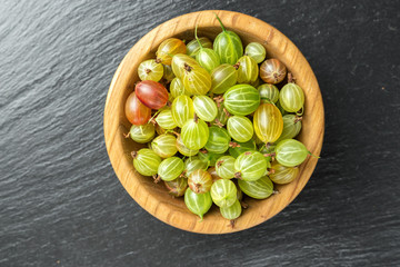 Ripe gooseberry in a wooden plate