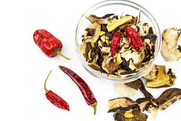 Dried mushrooms and chili peppers on a white background. Aromatic food ingredient. Traditional processing of mushrooms.