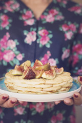Woman hand holding Belgian waffles with figs
