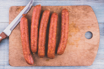 Smoked sausages on the board - top view