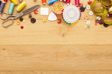 Collection of threads and buttons on wooden table background