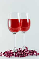 On a white background are two glasses with red wine