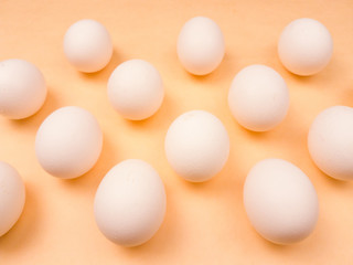 White easter eggs on pastel yellow background close up macro.