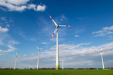 große Windräder stehen auf einem Feld und produzieren Ökostrom