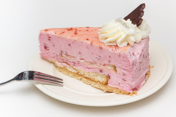 Strawberry cheese cake with chocolate heart on a white plate
