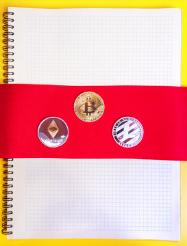 Gold bitcoins digital virtual money on a red band background. Metal gold money bitmoney Credit coins - bitkoin BTK , lithecoin LTC , etherum ETH digital cryptococci