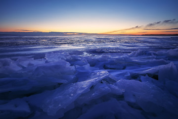 Beautiful winter landscape with sunset sky and frozen lake. Composition of nature.