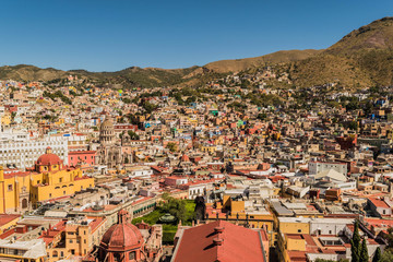Looking down on a UNESCO Heritage Site-Guanajuato City, Mexico, from up on a hill, with a view of many buildings, the center of the city, and colorful houses - 190929122