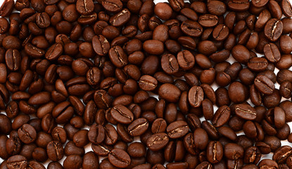 Background consisting of coffee beans. Many whole grains of Colombian coffee