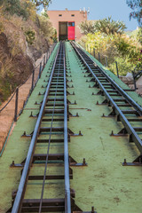 Funicular tracks with a green background, going up, with a red door at the top, in Guanajuato, Mexico - 190929709
