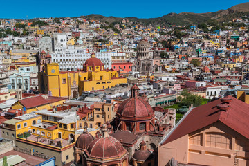 looking down on a UNESCO Heritage Site-Guanajuato City, Mexico, from up on a hill, with a view of the Basilica, Guanajuato University, many other buildings and colorful houses - 190929717