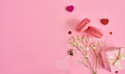 Valentines day background with a lot of different hearts, macaroons and gift box over pink...