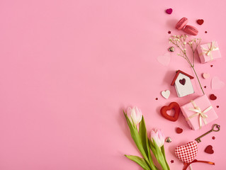 Valentines day background with a lot of different hearts,macaroons,pink tulips and gift box over pink background. Space for text