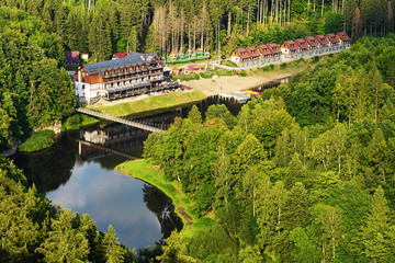 Barraged Lubachowskie Lake and Bystrzyca river valley landscape, Zagorze Slaskie, Lower Silesia, Poland. Aerial view on forested hills and resort hotel at the lake bank.