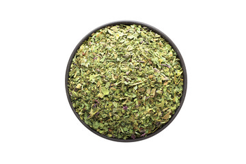 dried marjoram in clay bowl isolated on white background. Seasoning or spice top view