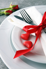 Festive table setting for Valentine's Day with fork, knife and rose
