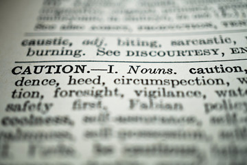 closeup of the word caution in the dictionary