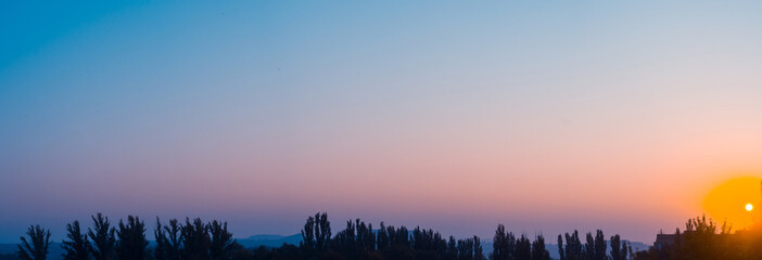 Landscape with dramatic light - beautiful golden sunset with saturated sky and clouds.