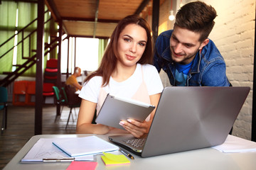 Obraz premium Teamwork concept.Young creative coworkers working with new startup project in modern office.Group of three people analyze data on desktop computer.Horizontal,blurred background