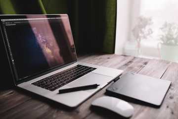 Laptop computer, graphics tablet and mouse at home office. Freelance lifestyle workplace