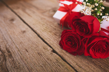 Valentines day background with red roses and gift box over wood board. Design mockup