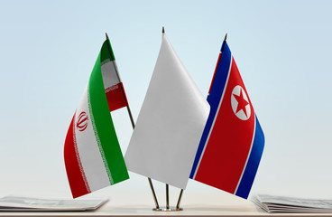 Flags of Iran and North Korea with a white flag in the middle