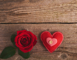 Valentines day background with red rose and heart over wood board
