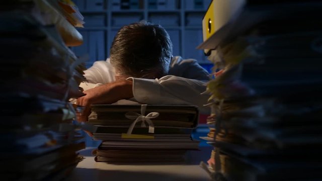 Exhausted overworked businessman sleeping in the office