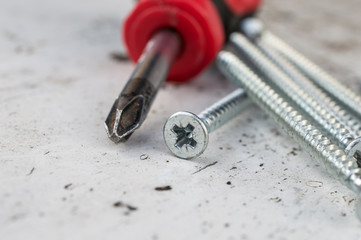 Screw and Screwdriver On White Wooden table