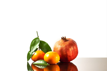 Beautiful fruits citrus family, clementines, tangerine, pomegranate and lemon on white shine background
