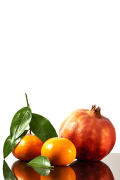 Beautiful fruits citrus family, clementines, tangerine, pomegranate and lemon on white shine background