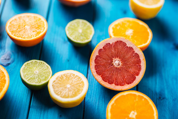 Oranges limet lemon and grapefruit on blue table.