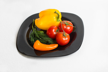 fresh vegetables lie on a black plate