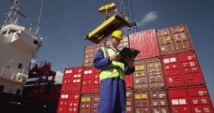 A young manager doing inspection rounds through an industrial harbor. Shot on RED Epic.