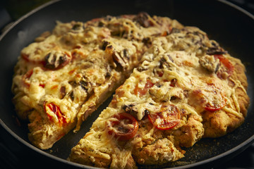 Homemade gluten-free cheese and tomato pizza in a frying pan