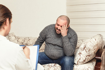 Fototapeta premium Psychologist conducting. Young man at the psychotherapist visit, talking about his problems with emotions, mental health