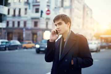 Portrait of a young guy with a phone in his hands.