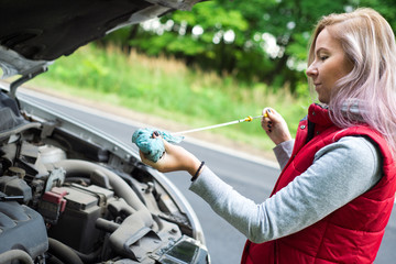 Girl checks the oil in the car's engine