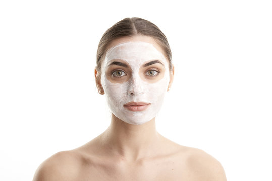 Beauty young female in facial treatment. Close-up shot of a woman with a mask applied to her face. Isolated on white background. 