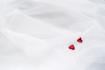 Red hearts on white veil