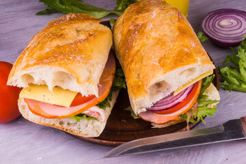 Fresh sandwiches with ham, cheese, lettuce, onions and tomatoes close-up