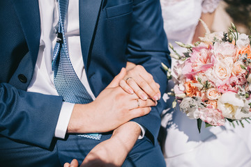 wedding couple, newlyweds hold hands with rings with wedding bouquet