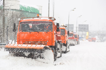 Snowplow trucks removing snow on the road street during blizzard snowstorm in Moscow, Russia.