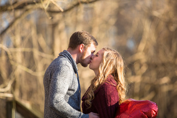 Attractive caucasian people together. Kissing, nuzzling, talking at the park outdoors.