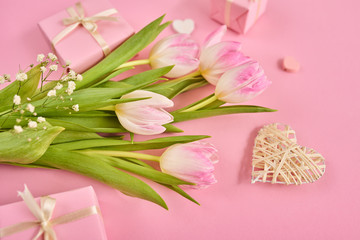Valentines Day background with pink tulips, gift box and hearts over pink background. Space for text