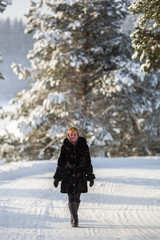 Young woman standing in the winter on a snowy road.