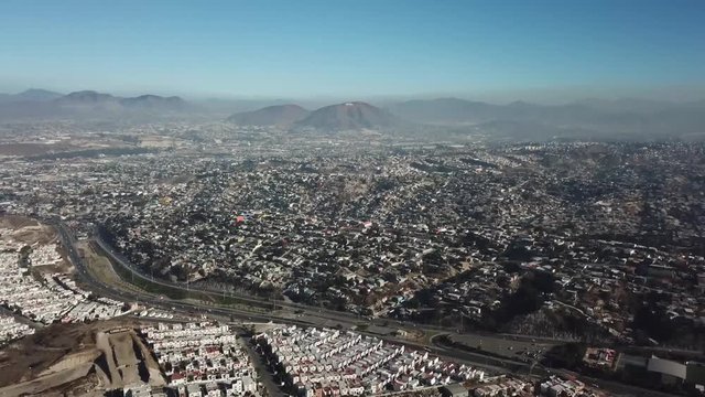 erial footage of a residential area in Tijuana, Baja California, Mexico during a Santana, local name for sand storm. High density of houses in a desert area, dusty sky.