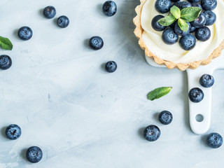 Vanilla tartlets with blueberry berries on light background.