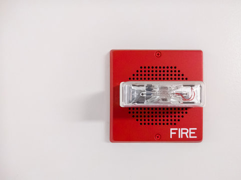 A red, modern-day fire alarm with LED lights to assist both visual and hearing impaired people.